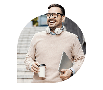 Smiling man holding laptop and coffee